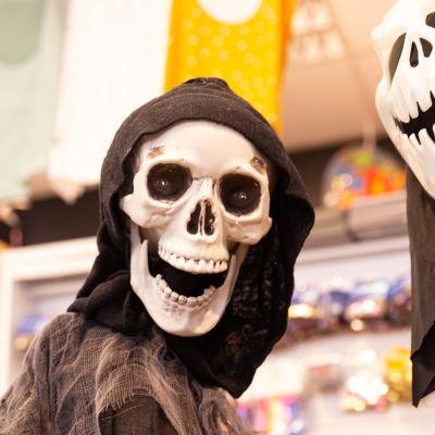 Lachendes menschliches Skelett im schwarzen Kapuzenumhang